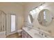 Bright bathroom featuring a double sink vanity, decorative mirrors, and a glass-enclosed shower for a luxurious feel at 2312 E Williams Dr, Phoenix, AZ 85024