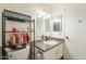 Functional bathroom featuring a single sink, vanity, storage rack and mirror at 3107 W Tuckey Ln, Phoenix, AZ 85017