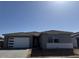 Modern single-story home featuring a tile roof, neutral color scheme, and a two-car garage at 32677 N Newby Dr, San Tan Valley, AZ 85143