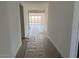 Long hallway with wood-look flooring leads to a bright living area with sliding glass doors and natural light at 32677 N Newby Dr, San Tan Valley, AZ 85143