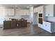 Spacious kitchen with wood-look floors, white cabinets, and a large island at 32677 N Newby Dr, San Tan Valley, AZ 85143