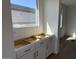 Bright kitchen area with white cabinets and a large window providing ample natural light at 32677 N Newby Dr, San Tan Valley, AZ 85143