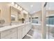 Bright bathroom with double vanity, quartz countertops, and marble floors with separate tub and shower at 3440 E Topeka Dr, Phoenix, AZ 85050