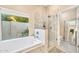 Bathroom with marble tub, shower, and a large window with backyard views at 3440 E Topeka Dr, Phoenix, AZ 85050