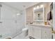 Bright bathroom features a glass-enclosed shower, white tiled walls, white vanity and fixtures, and tiled floors at 3440 E Topeka Dr, Phoenix, AZ 85050