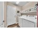 Functional laundry room with front load washer and dryer along with white walls and a utility door at 3440 E Topeka Dr, Phoenix, AZ 85050