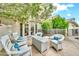 Outdoor patio features white wicker seating, fire pit table, beautiful greenery, and a bright blue sky at 3440 E Topeka Dr, Phoenix, AZ 85050
