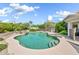 A pristine backyard pool with a spa is surrounded by lush landscaping and rock features at 3440 E Topeka Dr, Phoenix, AZ 85050