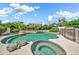 Sparkling pool and spa surrounded by lush landscaping in the backyard oasis at 3440 E Topeka Dr, Phoenix, AZ 85050
