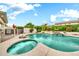 Sparkling pool with waterfall and spa surrounded by lush landscaping in a private backyard at 3440 E Topeka Dr, Phoenix, AZ 85050