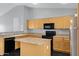 Clean kitchen features marble-look countertops and flooring, stainless steel refrigerator, black appliances and wood cabinets at 35656 N Shorthorn Trl, San Tan Valley, AZ 85143