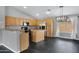 Well-lit kitchen featuring wood cabinets, stainless steel refrigerator, kitchen island and black marble-look flooring at 35656 N Shorthorn Trl, San Tan Valley, AZ 85143