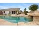 Backyard pool with rock waterfall feature and covered patio at 35656 N Shorthorn Trl, San Tan Valley, AZ 85143