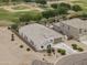 An aerial view shows the home with a tile roof, desert landscaping, and a park and baseball field in the background at 35773 N Loemann Dr, San Tan Valley, AZ 85143