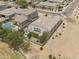 An aerial view shows the home's backyard with lush green grass, a patio, and a firepit at 35773 N Loemann Dr, San Tan Valley, AZ 85143