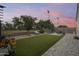 Spacious backyard with artificial turf, a cozy fire pit, and ample seating for outdoor gatherings at 35773 N Loemann Dr, San Tan Valley, AZ 85143