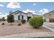 Well-maintained front yard with a variety of bushes, gravel landscaping, and blue shutters at 35773 N Loemann Dr, San Tan Valley, AZ 85143