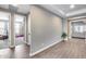 Hallway showcasing wood-look flooring and natural light leading to a bedroom and living room at 35773 N Loemann Dr, San Tan Valley, AZ 85143