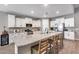 Bright kitchen with white cabinets, stainless steel appliances, granite countertops, and a center island with seating at 35773 N Loemann Dr, San Tan Valley, AZ 85143