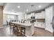 Modern kitchen featuring a large center island, stainless steel appliances, and stylish wood flooring at 35773 N Loemann Dr, San Tan Valley, AZ 85143