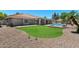 Well-maintained backyard boasts lush green lawn, rock landscaping, covered patio, and sparkling pool at 3822 E Florian Ave, Mesa, AZ 85206