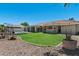 Backyard with green lawn, rock landscaping, covered patio, and sparkling pool offers outdoor enjoyment at 3822 E Florian Ave, Mesa, AZ 85206