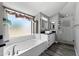 Bright bathroom features soaking tub, large window, vanity, and glass-enclosed shower at 3822 E Florian Ave, Mesa, AZ 85206