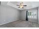 Spacious bedroom with neutral colors, a ceiling fan, and a window providing natural light at 3822 E Florian Ave, Mesa, AZ 85206