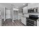 Corner view of updated kitchen featuring white cabinets, stainless steel appliances, and granite countertops at 3822 E Florian Ave, Mesa, AZ 85206