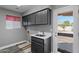 Well-lit laundry room with upper cabinets, a sink, and access to the backyard at 3822 E Florian Ave, Mesa, AZ 85206