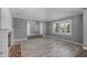 Bright living room with updated paint and flooring, centered around a brick fireplace and a large window at 3822 E Florian Ave, Mesa, AZ 85206