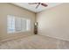 Bedroom featuring carpet, a ceiling fan, and plantation shutters for privacy and light control at 4107 W Mariposa Grande --, Glendale, AZ 85310