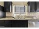 Kitchen sink with granite countertops, dark cabinets, stainless steel appliances, and tile backsplash at 4107 W Mariposa Grande --, Glendale, AZ 85310