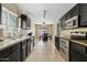 Well-lit kitchen with granite counters, stainless steel appliances, and dark wood cabinets at 4107 W Mariposa Grande --, Glendale, AZ 85310