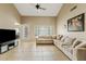 Bright living room featuring tiled floors, a ceiling fan, large windows and a sectional sofa at 4107 W Mariposa Grande --, Glendale, AZ 85310