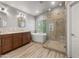 Well lit bathroom featuring double sinks with granite countertops, a tub, and glass shower at 4226 E Stanford Ave, Gilbert, AZ 85234