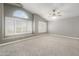 Bright bedroom with plush carpet, large windows, and a modern ceiling fan at 4226 E Stanford Ave, Gilbert, AZ 85234