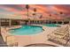 Sparkling community pool and lounge chairs surrounded by palm trees at sunset at 4655 E Farmdale Ave, Mesa, AZ 85206