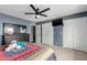 This main bedroom features a ceiling fan, television, closet, and blue accent wall at 4655 E Farmdale Ave, Mesa, AZ 85206