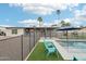 View of pool with blue chairs, a fence and palm trees, and outside TV at 5119 E Shaw Butte Dr, Scottsdale, AZ 85254