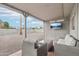 Inviting covered patio features outdoor furniture and wall-mounted TV, overlooking the gravel backyard at 5119 E Shaw Butte Dr, Scottsdale, AZ 85254