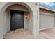 Close-up of front door entrance with arched entry and a welcome mat at 5119 E Shaw Butte Dr, Scottsdale, AZ 85254