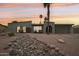 Inviting single-story home with desert landscaping and a palm tree at sunset at 5119 E Shaw Butte Dr, Scottsdale, AZ 85254