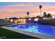 Inviting pool glows at twilight, surrounded by well-maintained fencing and an umbrella for shade at 5119 E Shaw Butte Dr, Scottsdale, AZ 85254
