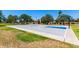 Full basketball court with blue accents and lush green grass, surrounded by mature trees and neighborhood homes at 5216 W Oraibi Dr, Glendale, AZ 85308