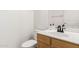 Bathroom featuring a wood vanity, white sink and toilet, and a framed mirror at 5216 W Oraibi Dr, Glendale, AZ 85308