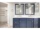Bathroom featuring double sinks, framed mirrors, blue cabinets, and marble countertops at 5216 W Oraibi Dr, Glendale, AZ 85308