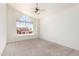 Carpeted bedroom featuring a large window, and a ceiling fan at 5216 W Oraibi Dr, Glendale, AZ 85308
