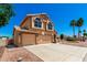 Beautiful two-story home with a three car garage, desert landscaping and palm trees in the yard at 5216 W Oraibi Dr, Glendale, AZ 85308
