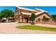 Beautiful two-story home with three car garage, green grass and desert landscaping with a fountain at 5216 W Oraibi Dr, Glendale, AZ 85308